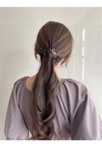 Detail of bird nest hair claw clip with tortoiseshell pattern on a low ponytail