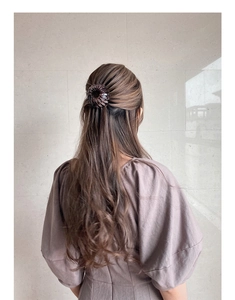 Detailed view of brown bird nest telescopic hair clip styling a high ponytail bun
