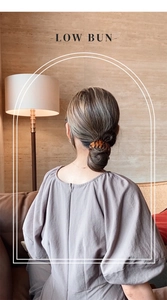 Detail view of amber bird nest hair clip securing a low bun with chic tortoiseshell pattern
