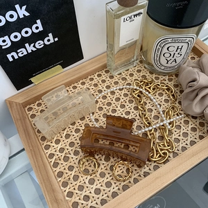French vintage set with amber resin hair claws, gold chain necklaces and rings on rattan tray