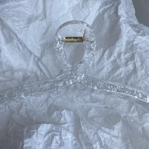 Close-up of minimalist hair claw clip with white ink splatters and gold metal spring