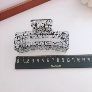 Detail view of 11cm large ink-patterned acrylic hair claw clip with size ruler