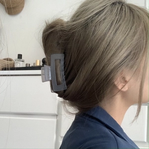Detail view of a smoke gray frosted square hair claw clip for a chic French bun style
