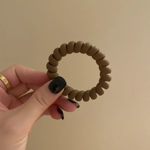 Vue détaillée d'un élastique spirale marron café de type cordon de téléphone