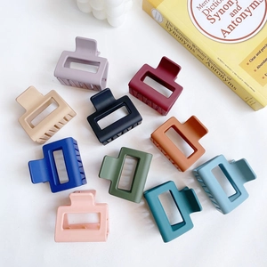 Flat lay of rectangular matte hair claws in ten Morandi colors including pink and navy