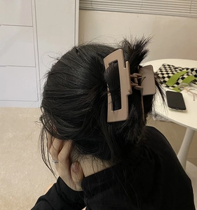 Mocha matte rectangular large hair claw clip styled on dark long hair in a close-up detail
