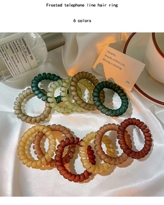 Détail de douze chouchous spirales mats aux tons vert terreux et café