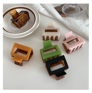 Detail view of 5cm rectangular hair claws in six colors on a stylish ceramic plate