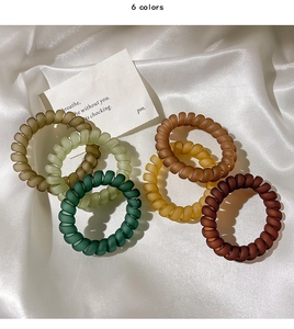 Vue détaillée de 6 élastiques à cheveux spirale mats tons terre sur tissu soie