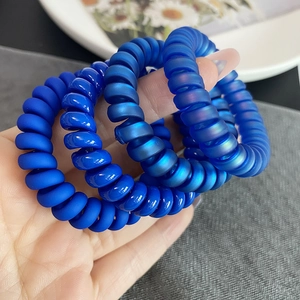 Lot de 4 élastiques spirale bleus aux finis mats, métalliques et irisés sur main