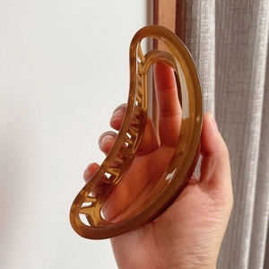 Close-up of a large amber resin shark hair claw clip with non-slip teeth for thick hair