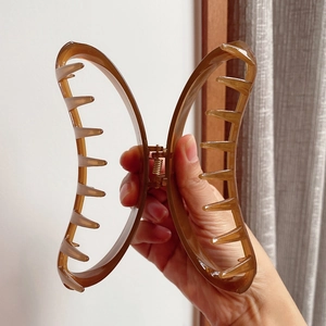 Large amber translucent crescent hair claw clip for thick hair held in hand