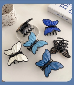 Detailed set of butterfly hair claws in solid colors and hollow designs on a white table