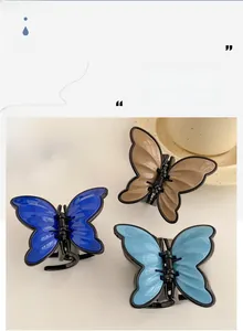 Detailed view of three butterfly hair clips in navy blue, light blue, and khaki finishes