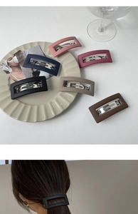 Close-up of matte rectangular hollow hair clips in diverse Morandi colors on a ceramic tray