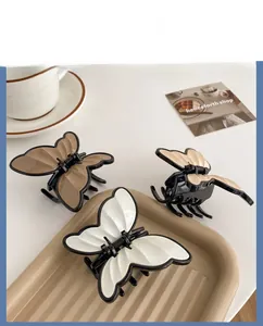Close-up of elegant butterfly hair claw clips in cream, beige, and light brown colors