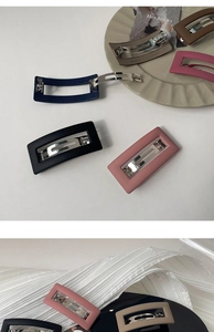 Close-up of minimalist matte rectangle hair clips in multiple colors with metallic springs
