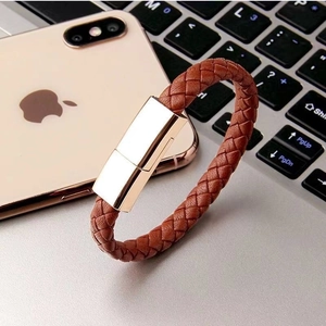 Primer plano de pulsera cable USB de cuero trenzado marrón con conector dorado