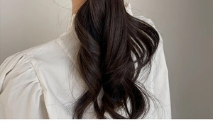 Detailed view of dark brown wavy hair extensions with natural shine and soft texture