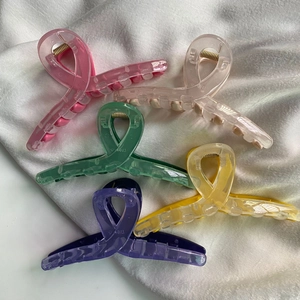 Five assorted glossy rectangle butterfly hair claws in vibrant colors on white silk