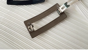 Detail view of the matte rectangular hair clip and the durable silver metal spring mechanism