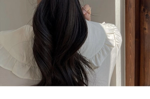 Detailed view of long wavy ponytail hair extension in natural dark brown or black shade