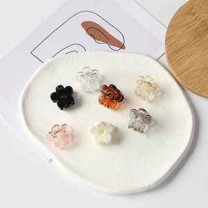 Lot de 7 mini pinces à cheveux en forme de fleur de couleurs variées sur plat blanc