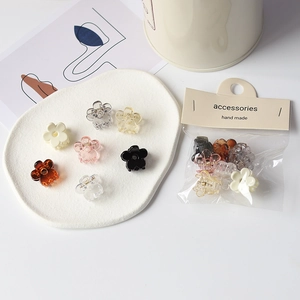 Mini pinces à cheveux fleurs colorées sur un plateau avec emballage de vente