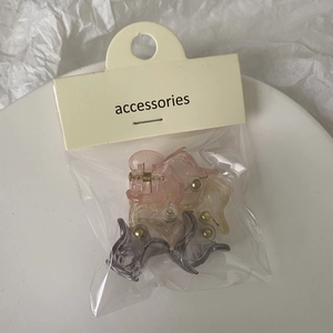 Close-up of translucent mini jelly hair clips in pink yellow and grey packaging