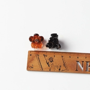 Mini pinces à cheveux fleur de 2cm en ambre et noir présentées avec mesure