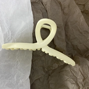 Detail view of the 13cm matte cream yellow criss-cross hair claw clip for thick hair
