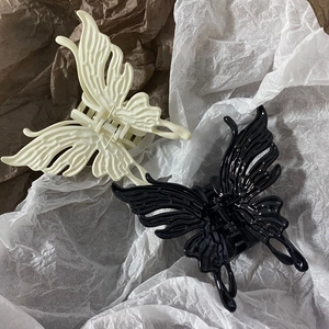 Detailansicht der hohlen Schmetterling-Haarklammern in Schwarz und Cremeweiß