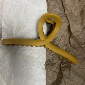 Macro detail of large matte ginger hair claw clip featuring twisted design and strong spring