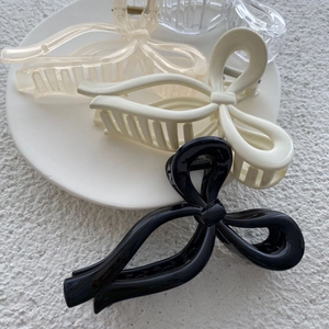 Large elegant ribbon bow hair claw clips in black, cream, and clear glossy finishes
