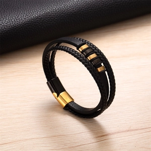 Vue détaillée du bracelet homme en cuir tressé avec fermoir magnétique doré et tubes en métal