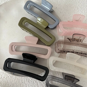 Flat lay of eight colorful rectangular hair claws in matte and translucent finishes