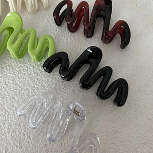 Dettaglio di mollette per capelli ondulate da 13cm in colori nero lucido e ambra
