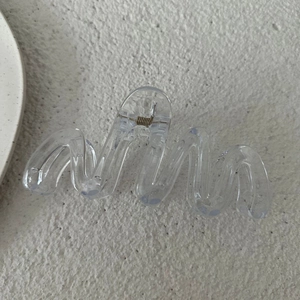 Dettaglio di un fermaglio per capelli ondulato trasparente da 13 cm con molla in metallo