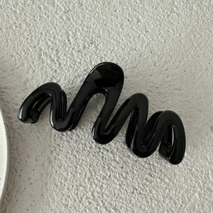 Dettaglio della pinza per capelli ondulata nera lucida da 13 cm con finitura moderna