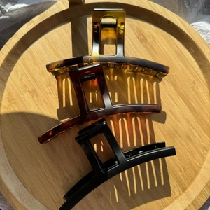 Tre fermagli per capelli opachi a tartaruga e neri su vassoio in bambù