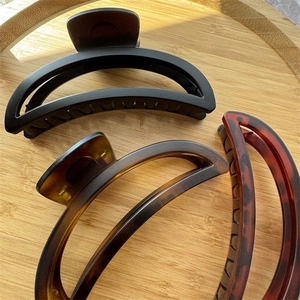 Crescent matte shark hair clips in black and tortoiseshell finish on wood tray