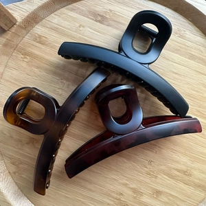 Trois grandes pinces à cheveux mates de style français sur plateau en bois avec motif écaillé