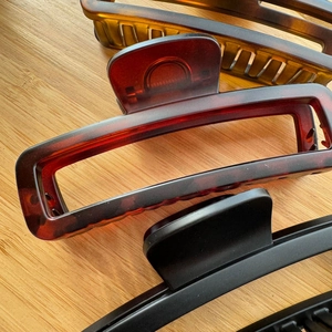 Detail view of large 12cm rectangular hair claws in amber tortoiseshell and matte black