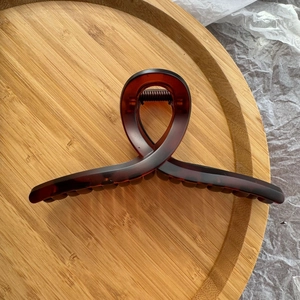 Détail du clip à cheveux en résine ambre avec un design élégant en forme de ruban