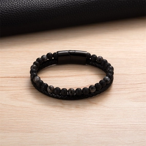 Dettaglio macro del bracciale in pelle intrecciata con perle laviche e chiusura magnetica