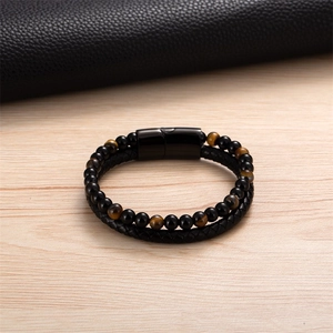 Dettaglio di un bracciale multistrato da uomo in pelle con perle occhio di tigre e chiusura