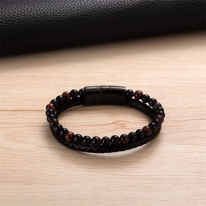 Dettaglio di perline occhio di tigre e bracciale in pelle con chiusura magnetica opaca