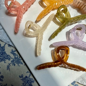 Detail of colorful jelly matte hair claws with crisscross design and metal springs
