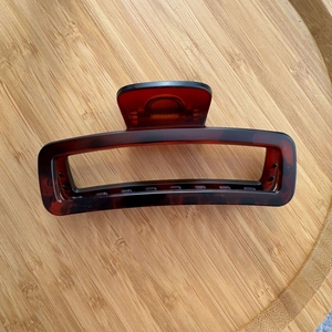 Detailed view of a 12cm amber tortoiseshell hair claw clip with strong metal spring