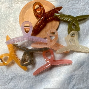 Close-up of assorted 13cm matte jelly color shark hair clips on a wooden tray